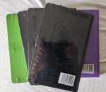 5 Notizbücher in DIN A5 - eines in Grün, drei in Schwarz und eines in Lila, von links nach rechts